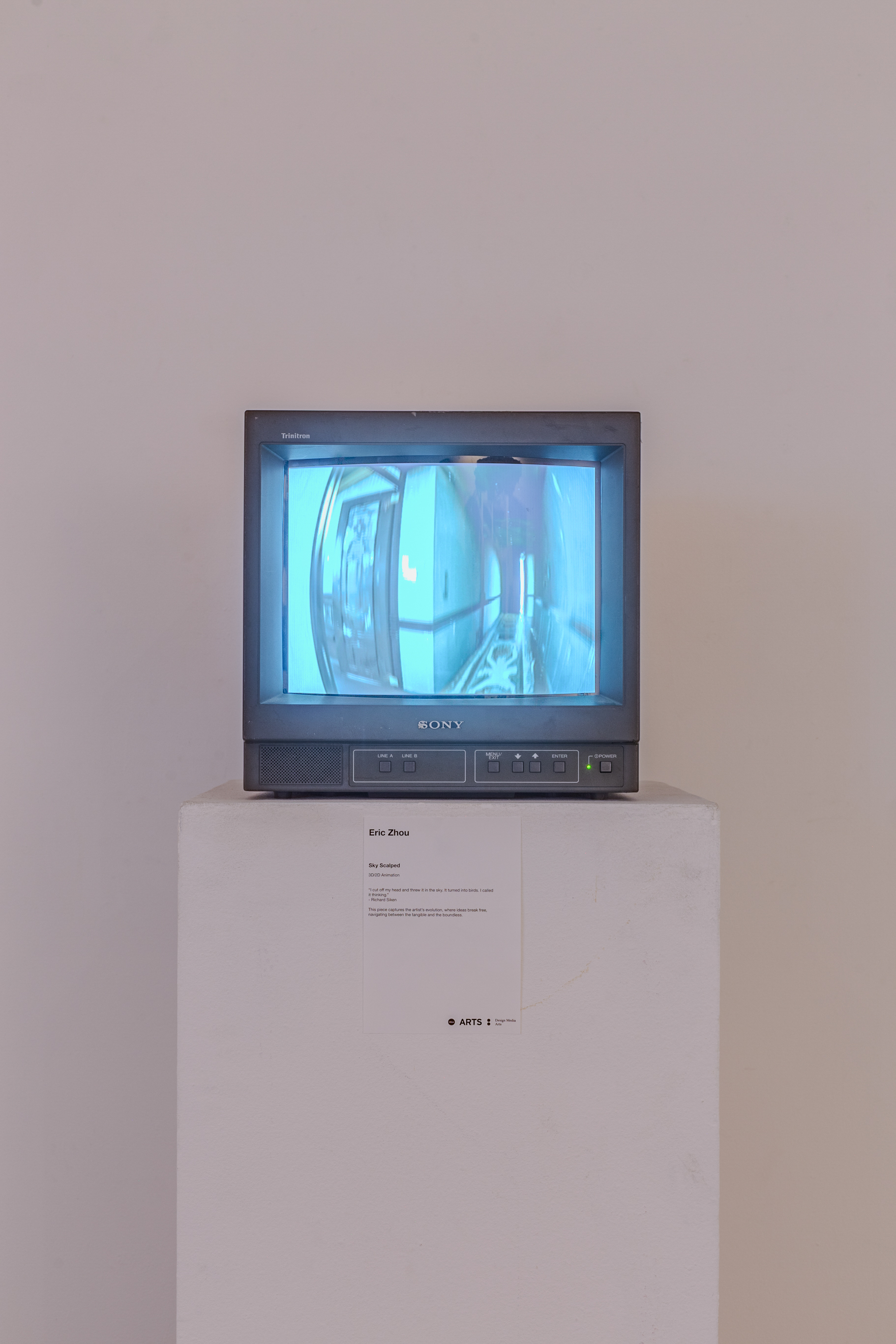 A CRT TV sits on top of a white podium with a white wall in the background.